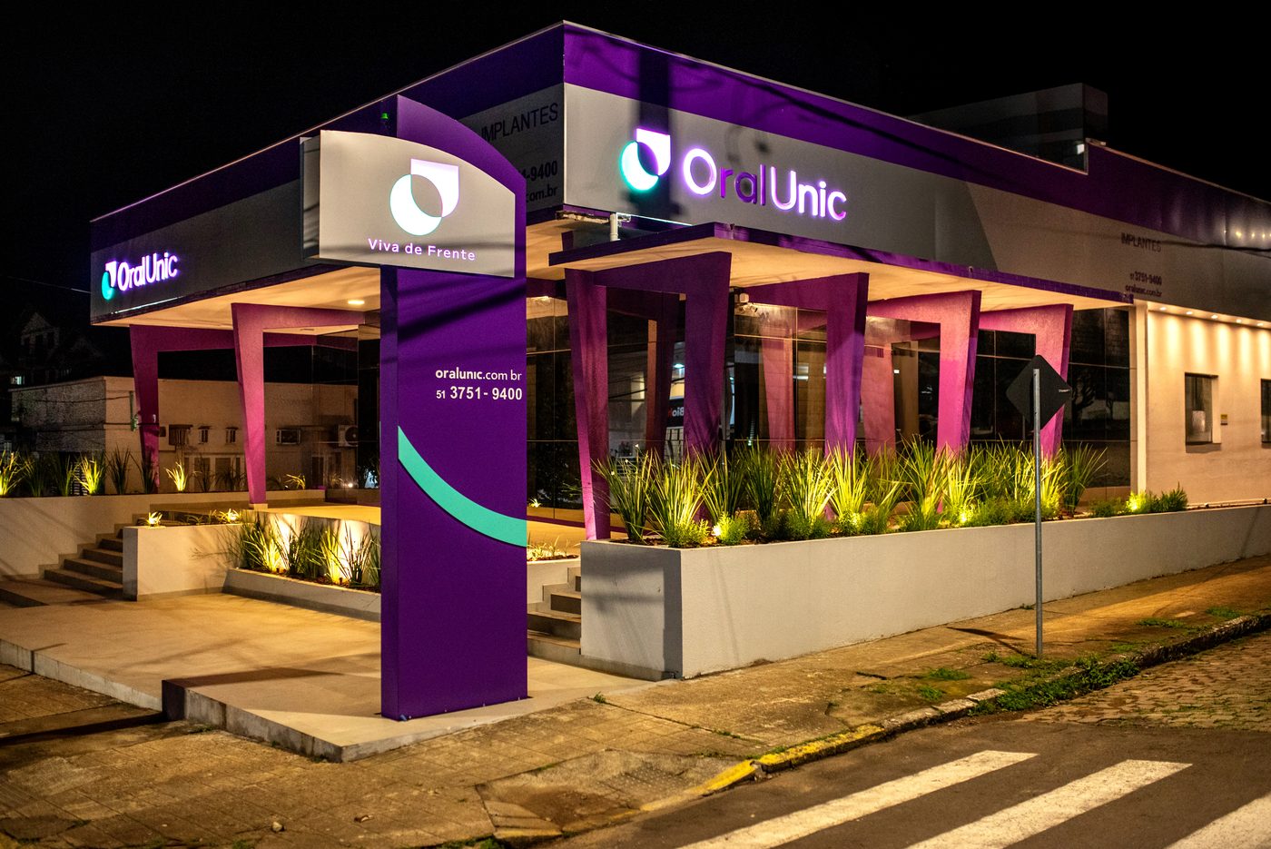 Fachada iluminada da Oral Unic Encantado à noite